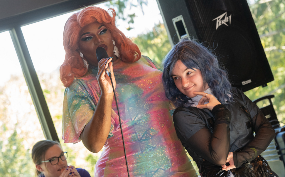 two people in wigs standing next to each other in front of a microphone
