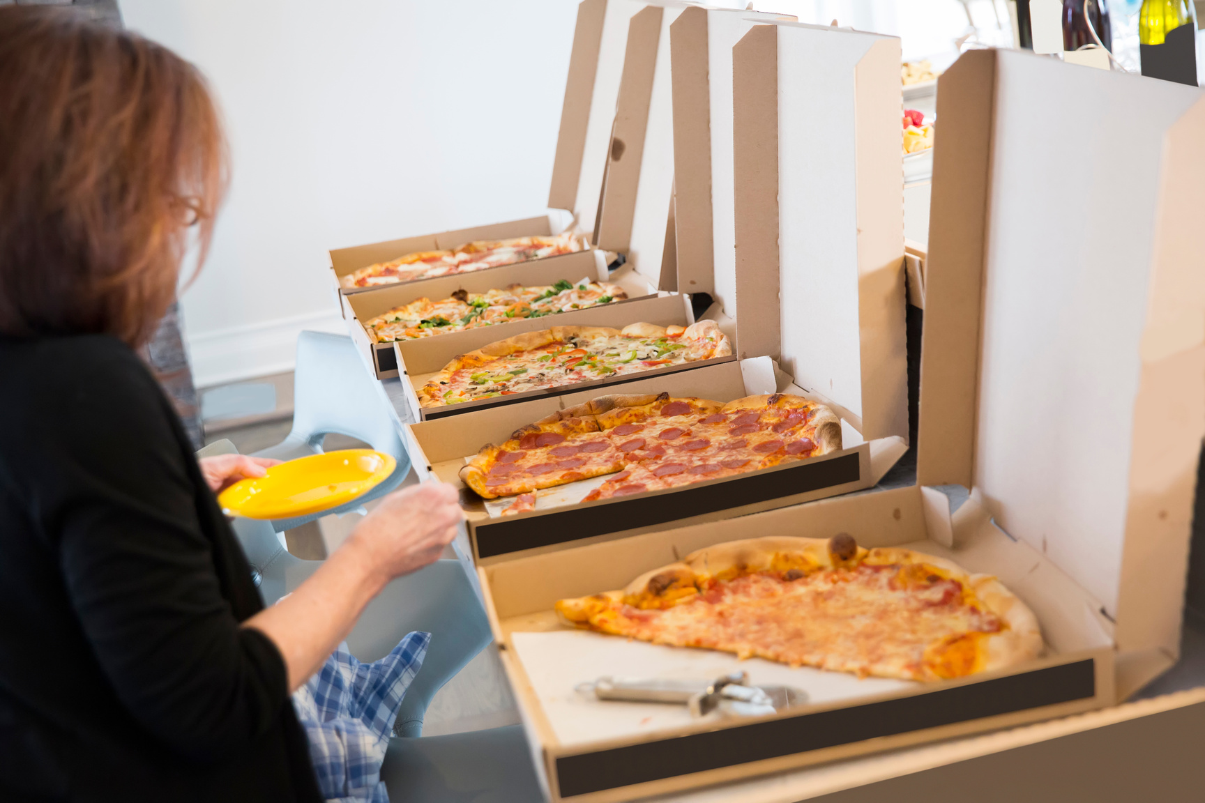 a table full of pizzas in boxes