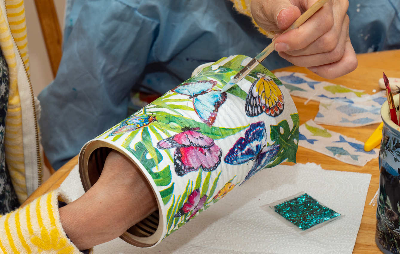 a person is painting a container with colorful butterflies on it