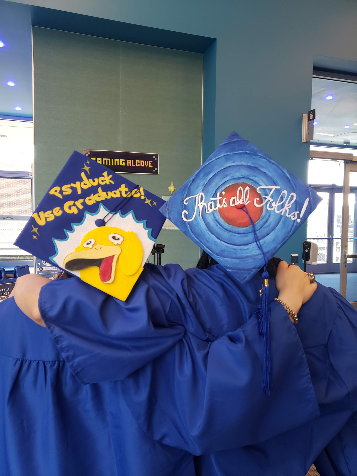 two people wearing decorated graduation hats 